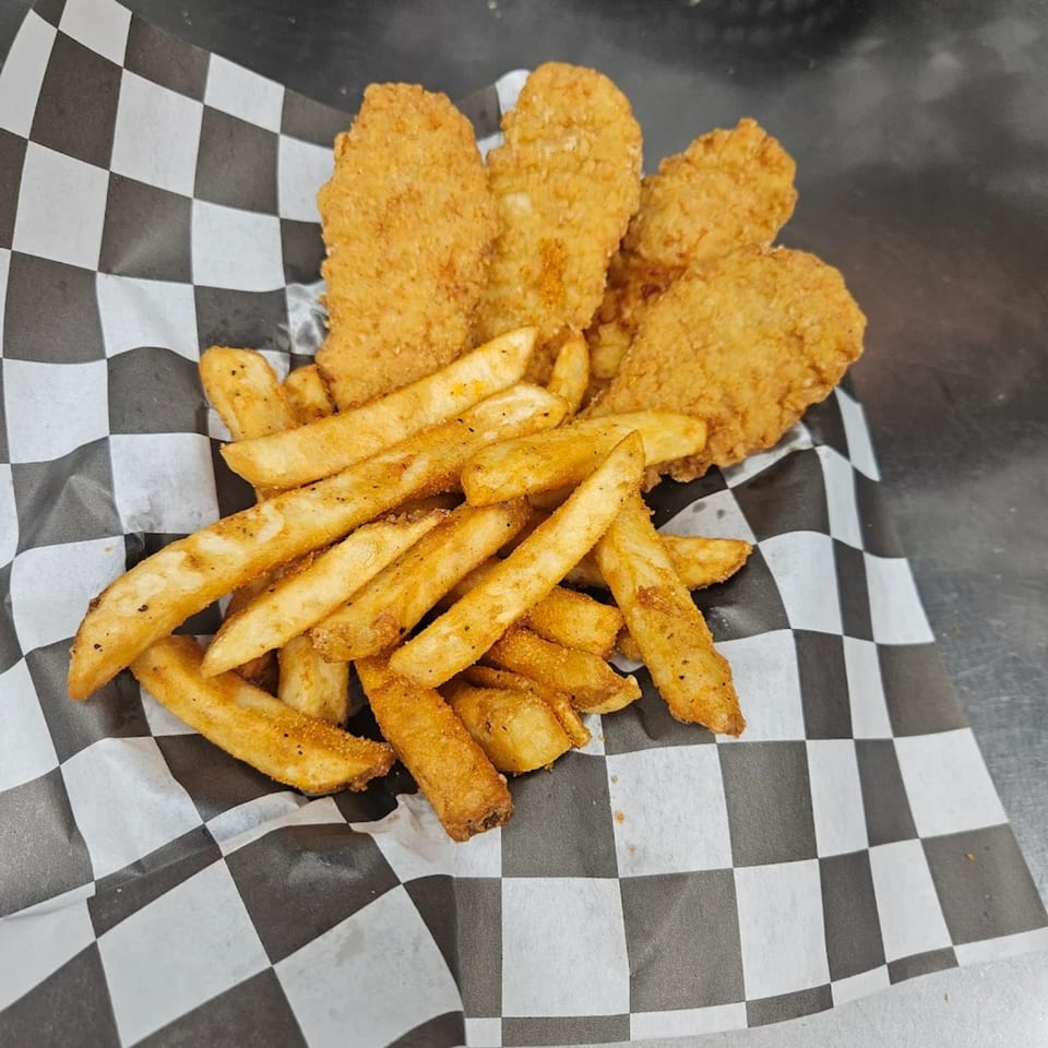 Crispy chicken tenders and seasoned fries served in a checkered paper-lined basket from THE STONE.
